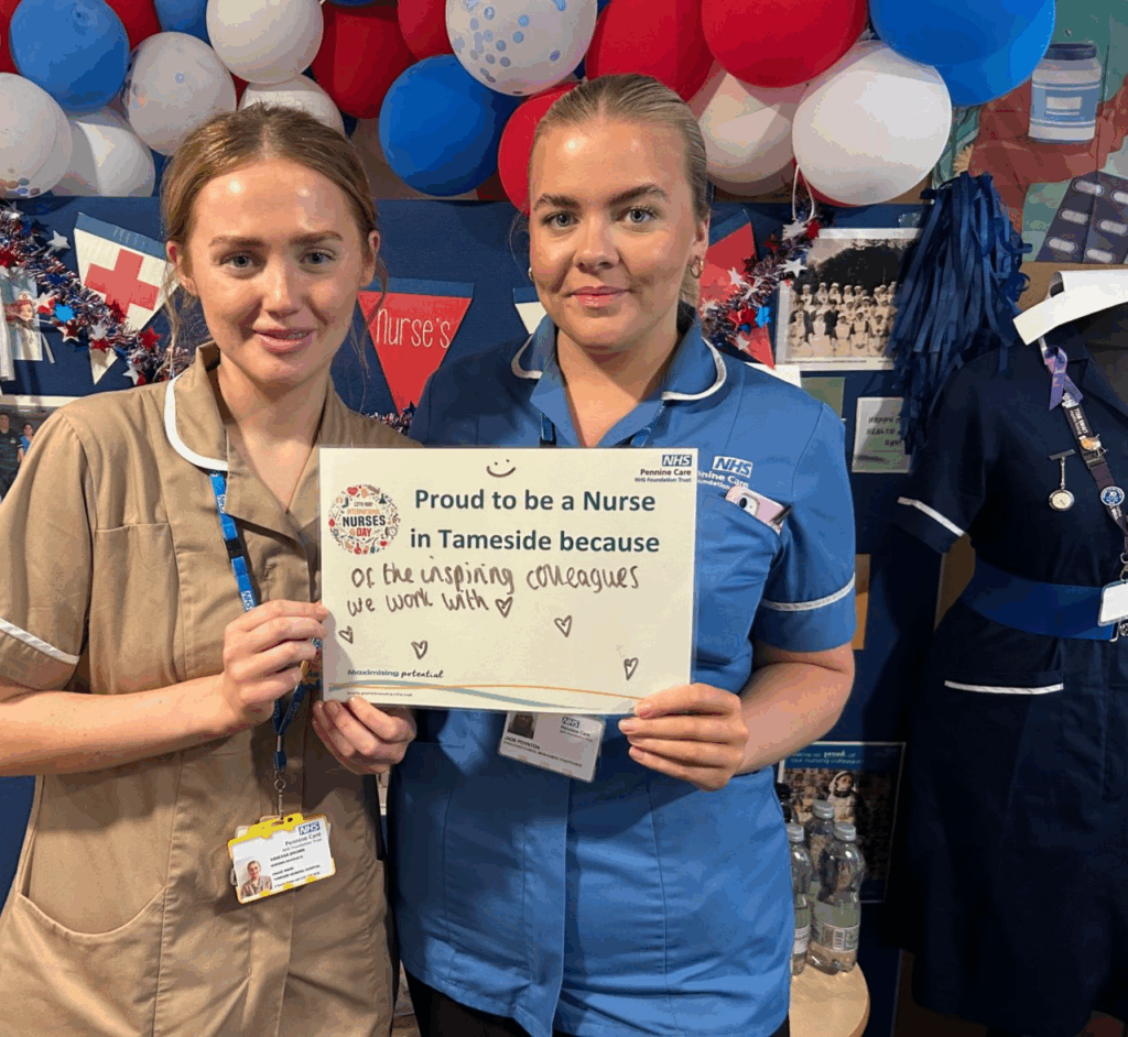 Two Pennine Care Nurses holding a sign that reads "Proud to be a Nurse in Tameside because of the inspiring colleagues we work with."