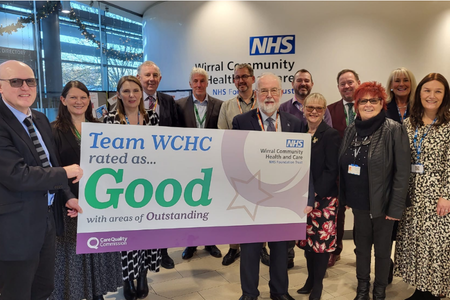 Photo of Wirral Community NHS Foundation Trust senior leadership holding a CQC good banner.