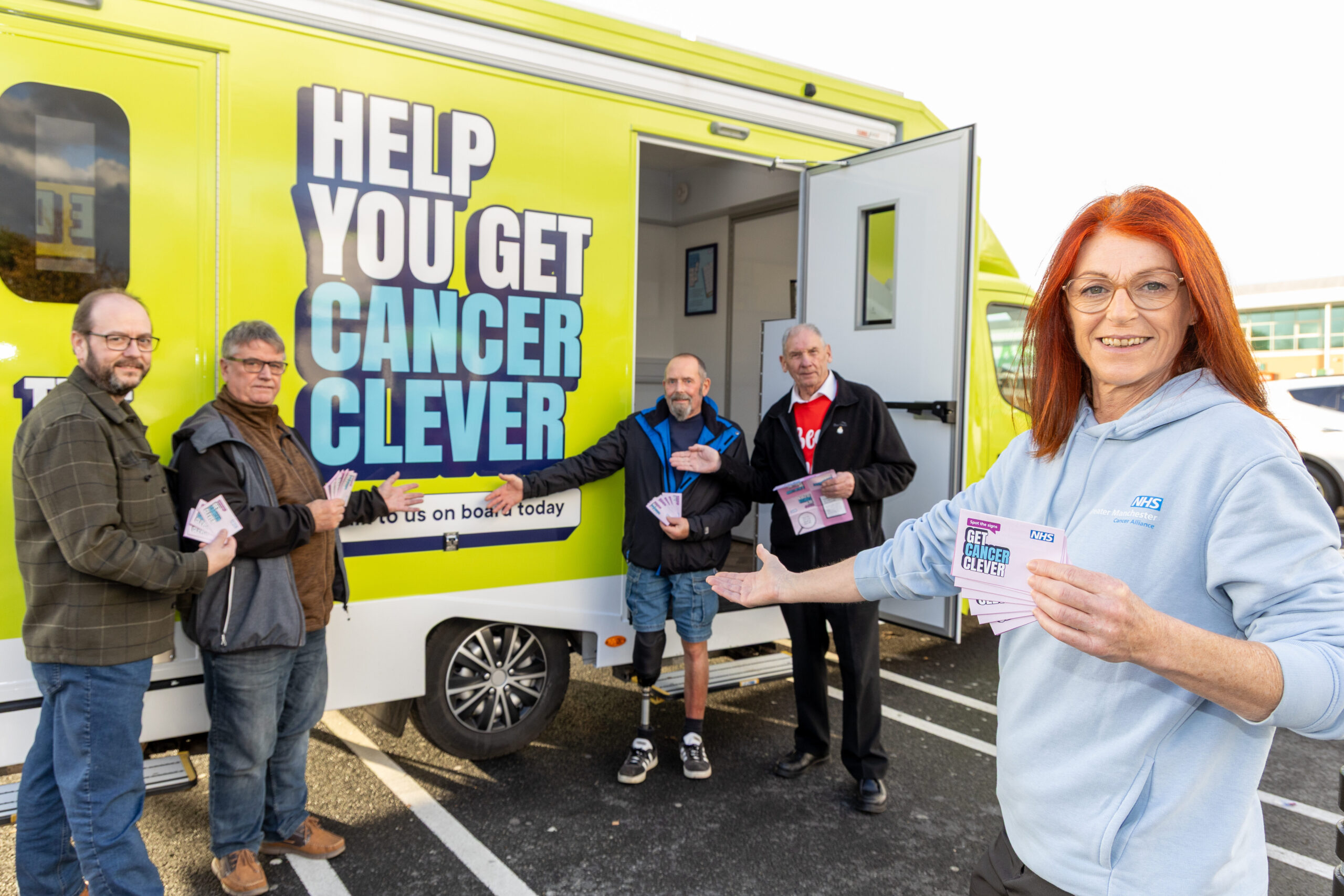 A group of people standing in front of the van and pointing to it